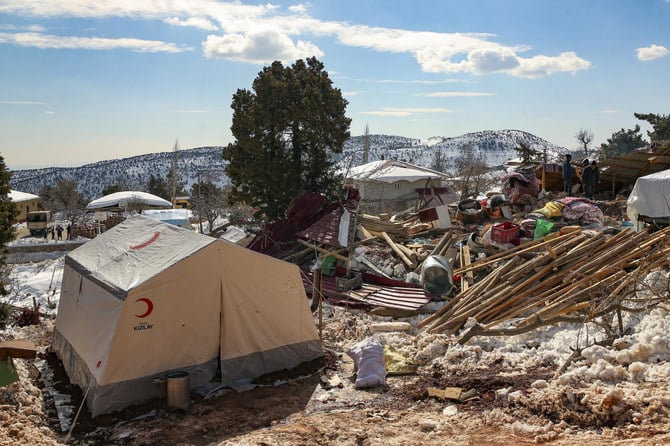 People walk by collapsed houses in Buyuknacar village in Kahramanmaras, Turkey, Wednesday, Feb. 15, 2023. (AP)