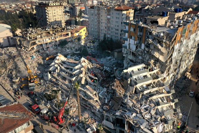 Rescue teams search for people as cranes remove debris from destroyed buildings in Antakya, southeastern Turkey, on Feb. 10, 2023. (AP Photo/Hussein Malla)
