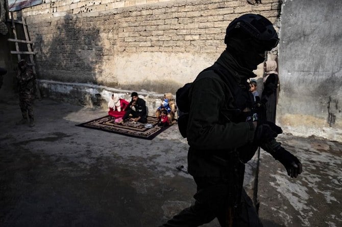 A member of the Syrian Kurdish Asayish security forces walks past a house during a raid against suspected Daesh group fighters in Raqqa, the extremist group's former defacto capital in Syria, on Jan. 29, 2023. (AFP)