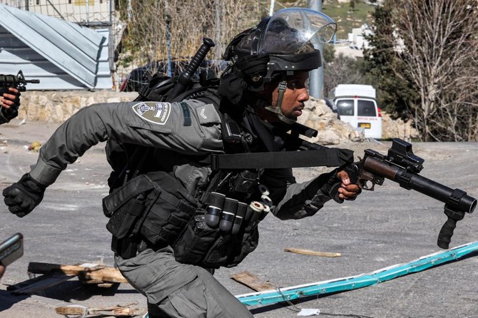 An Israeli border guard runs with a riot-control gun during clashes with Palestinians amidst a declared general strike by Palestinians against house demolitions carried out by Israeli authorities. (AFP)