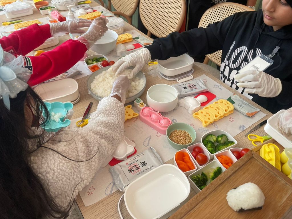 Along with making rice balls, the children were handed several shaped tools to help cut vegetables, create variously shaped rice figures and decorate their lunchboxes. (ANJ Photo)