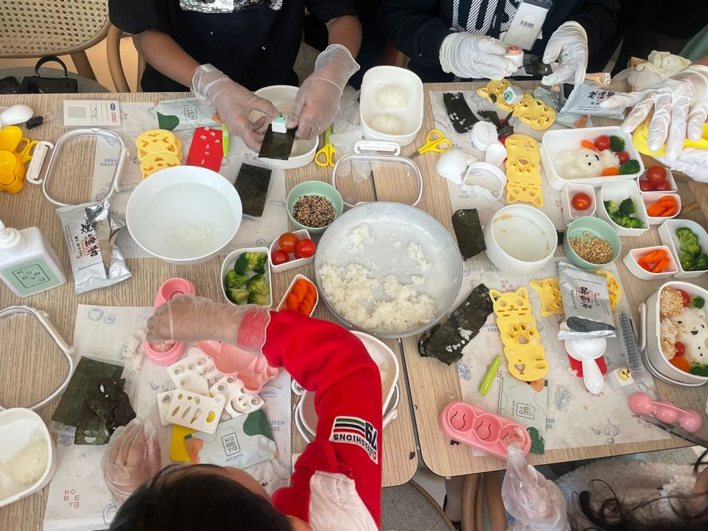 Along with making rice balls, the children were handed several shaped tools to help cut vegetables, create variously shaped rice figures and decorate their lunchboxes. (ANJ Photo)