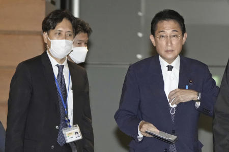 Senior aide to the prime minister Masayoshi Arai (left), walks next to Prime Minister Fumio Kishida at the Prime Minister's official residence in Tokyo, Dec. 12, 2022. (Kyodo News via AP)