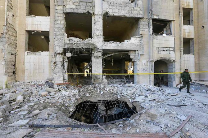 Syrian security forces members inspect a building damaged in a reported Israeli missile strike in Damascus on February 19, 2023. (AFP)