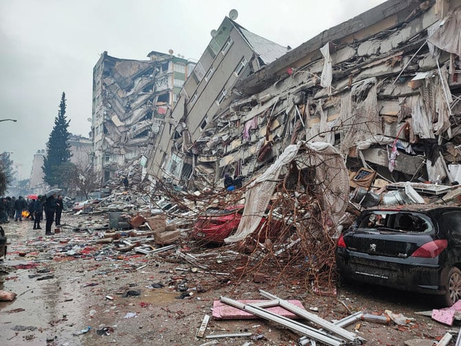 People stand in front of collapsed buildings following an earthquake in Kahramanmaras, Turkey February 6, 2023. (Reuters)