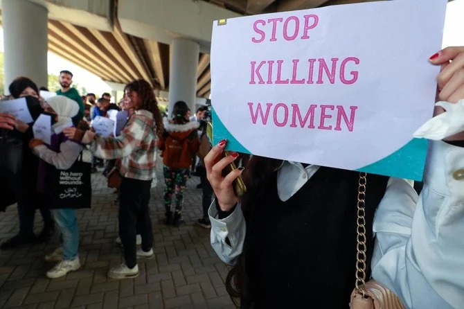 Iraqi women's rights activists lift placards during a rally near the Supreme Judicial Council in Baghdad on February 5, 2023, to protest the killing of Iraqi youtuber Tiba al-Ali by her father in Diwaniyah. (AFP)