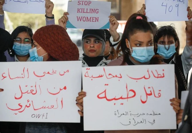 Iraqi women's rights activists lift placards during a rally near the Supreme Judicial Council in Baghdad on February 5, 2023, to protest the killing of Iraqi youtuber Tiba al-Ali by her father in Diwaniyah. (AFP)
