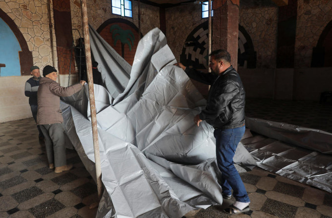 People set up a tent in a hall as they take shelter inside a venue, after they were struck by earthquakes in rebel-held Idlib, Syria on Feb. 21, 2023. (Reuters)