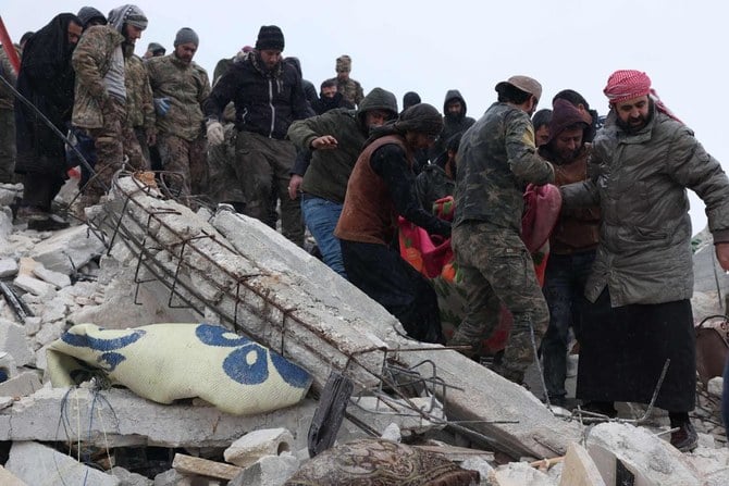 Residents and rescuers recover a victim from the rubble of a collapsed building following an earthquake in the village of Besnaya in Syria’s rebel-held northwestern Idlib province on the border with Turkiye, on February 6, 2022. (AFP)