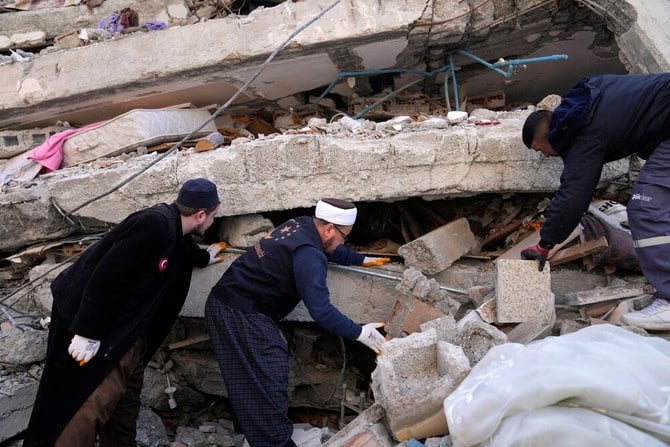 People and emergency teams search for survivors in the rubble of a destroyed building, in Iskenderun town, southern Turkiye, on Feb. 7, 2023. (AP)