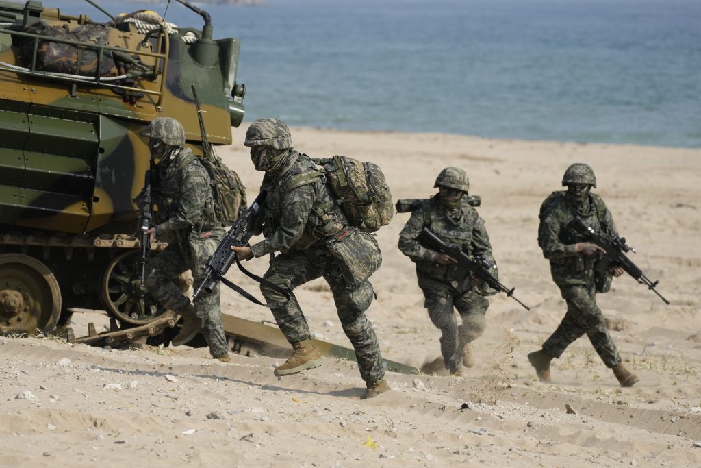 South Korean Marines run out from an amphibious assault vehicle after landing on the beach during the combined military amphibious landing exercise between South Korea and the U.S, called Ssangyong exercise, in Pohang, South Korea, Wednesday, March 29, 2023. (AP Photo)