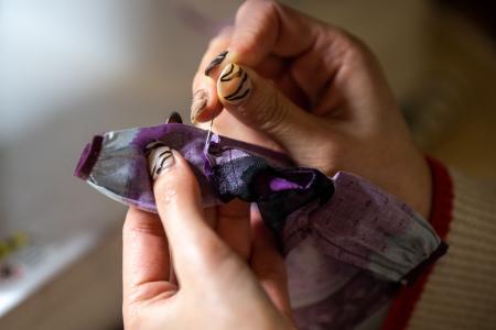 This photo taken on January 24, 2023 shows Ryoko Baba, a 33-year-old graphic designer, sewing a costume for her Licca-chan dolls at home in Tarui, Gifu Prefecture. (AFP)
