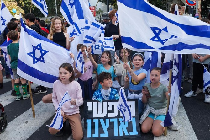Protesters blocked the main highway from Tel Aviv to Jerusalem on Wednesday, waving blue and white Israeli flags. (AFP)