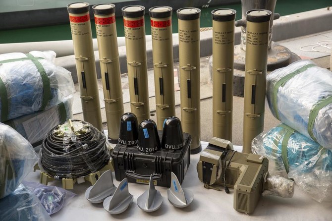 Anti-tank missiles and medium-range ballistic missile components seized by the UK Royal Navy sit pier side at an undisclosed location in the Middle East on Feb. 26, 2023. (AP Photo)
