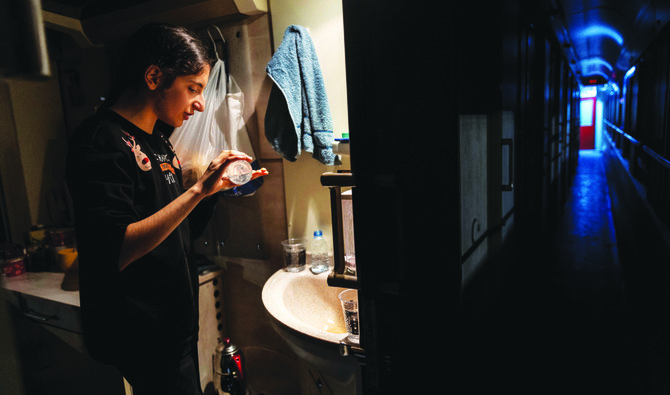 Nehir Karan, 13, pours sanitizer on her hands before going to bed in their carriage at Iskenderun station, where train carriages have been turned into temporary shelters for victims of the Turkiye earthquake. (Reuters)