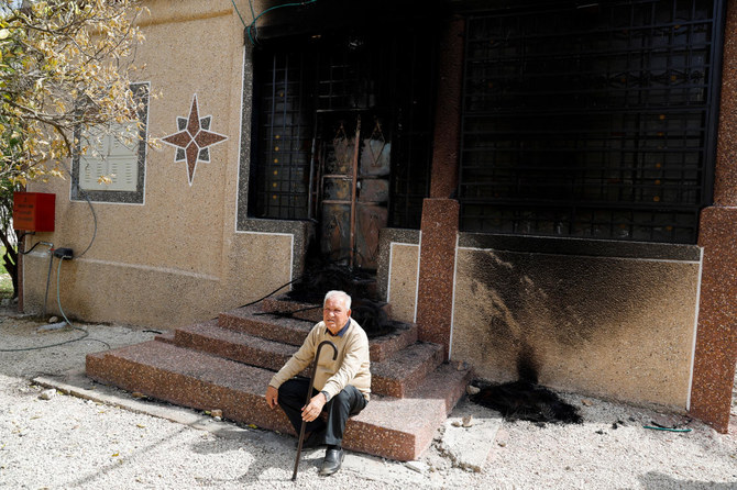 A Palestinian sits in front of a burned house after an Israeli settlers’ rampage in Hawara on Mar. 5, 2023. Hawara has been the scene of a violent rampage last week by dozens of settlers seeking revenge for the shooting of two Israeli brothers. (Reuters)