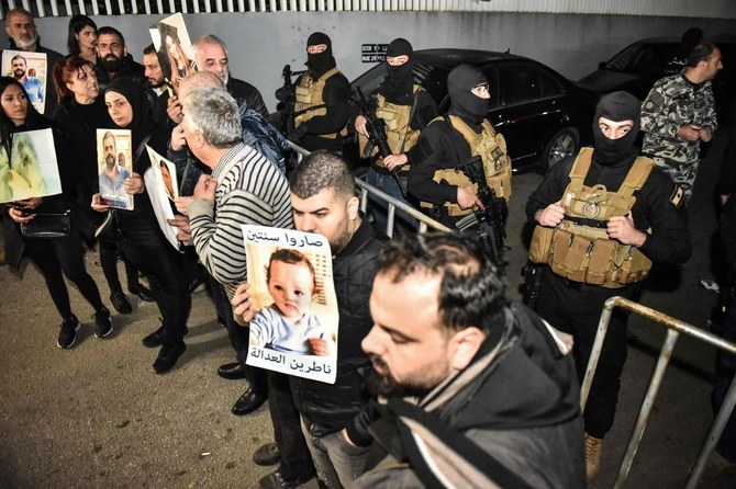 Family relatives holding up pictures of their beloved ones who were killed in the Aug. 4, 2020 Beirut port blast. Victims’ families have welcomed the condemnation of systematic interference in its investigation at a Geneva conference. (AFP/File)