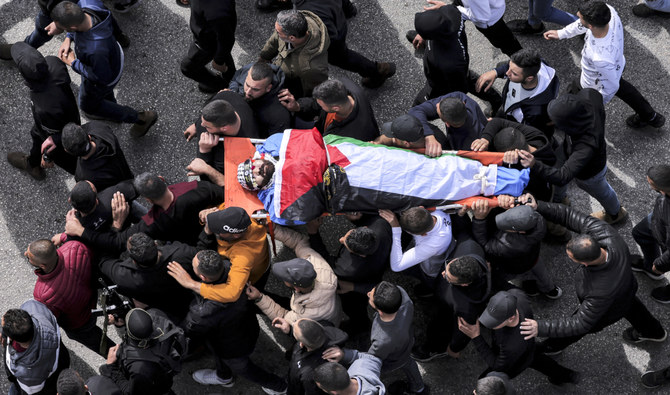 Mourners march with the body of one of several Palestinians killed the previous day in an Israeli army raid in the Jenin camp for Palestinian refugees, during their funeral in the camp on March 8, 2023. (AFP)