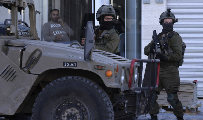 Israeli soldiers stand guard during an operation near the Jit junction west of Nablus in the occupied northern West Bank on March 12, 2023. (AFP/File)