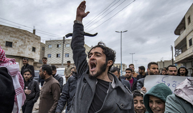 People chant slogans as they march during a rally marking the 12th anniversary of the start of the uprising against Syrian president Bashar Al-Assad and his government, in Tabqa in Raqa province on March 15, 2023. (AFP)