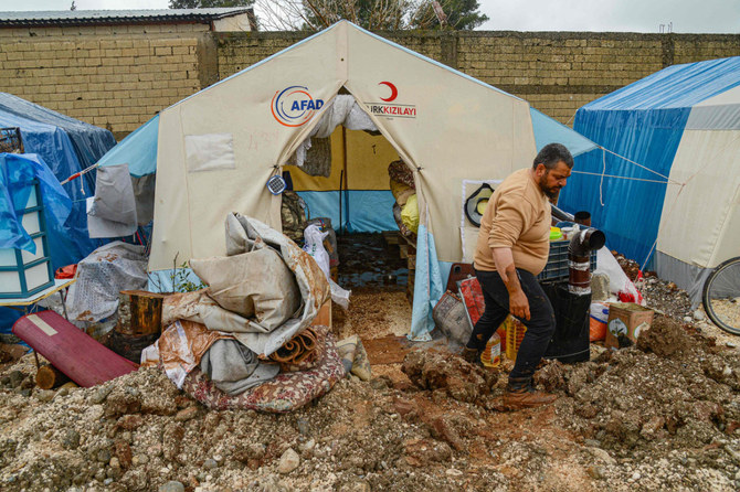 A man cleans from mud a tent following floods in Adiyaman, southeastern Turkey, on March 16, 2023. (AFP)