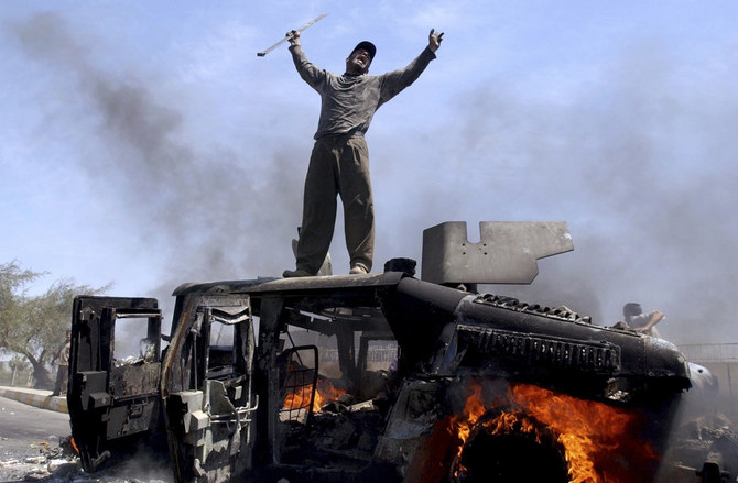An Iraqi man celebrates atop of a burning US Army Humvee in the northern part of Baghdad on April 26, 2004. (AP File)
