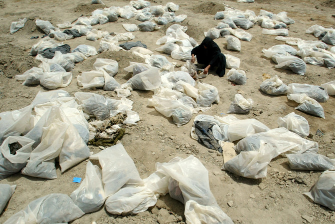 In this June 1, 2003 photo, an Iraqi woman looks inside plastic bags containing personal belongings for clues to identify her missing son at a mass grave in Mahawil, south of Baghdad, where some 5,000 of Iraqi Shi'ite Muslims were found. (Reuters file)Iraqi soldiers are seen running away on the banks of the Tigris river as US tanks roll into Baghdad, outside Saddam Hussein's presidential palace, on April 7, 2003. (AP)