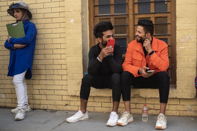 Young men chat near Al-Mutanabbi street in Baghdad, Iraq, Friday, Feb. 24, 2023. Two decades after a U.S.-led invasion, Iraqâ€™s capital today is full of life and a sense of renewal, its residents enjoying a hopeful, peaceful interlude in a painful modern history. (AP Photo/Jerome Delay)