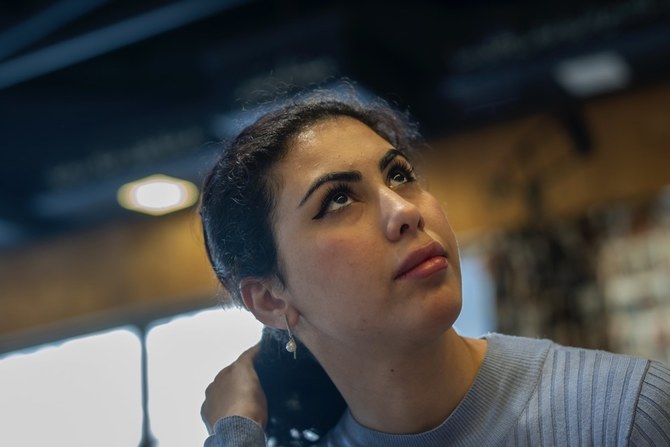 Noor Alhuda Saad, 26, a Ph.D. candidate at Mustansiriya University who describes herself as a political activist, sits in a Baghdad cafe on Wednesday, March 1, 2023. (AP Photo/Jerome Delay)