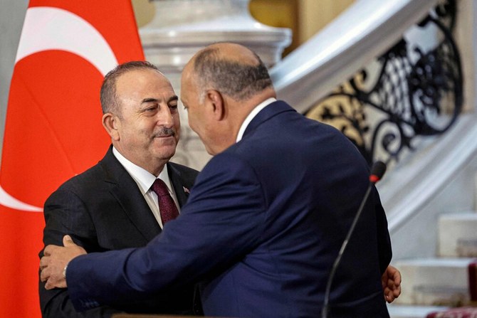 Egypt’s Foreign Minister Sameh Shoukry greets his Turkish counterpart Mevlut Cavusoglu in Cairo on Mar. 18, 2023. (AFP)