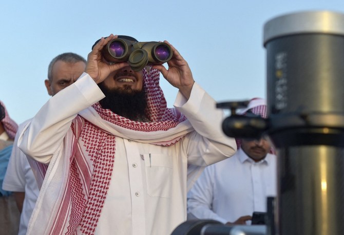 A Saudi man uses binoculars to spot the first crescent of the moon, marking the start of the holy month of Ramadan, in Taif, Saudi Arabia. (File/AFP)