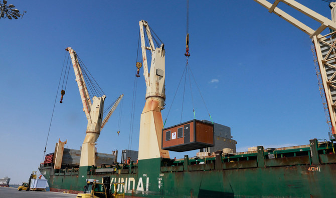 Workers load cabins and caravans used during the football World Cup in Qatar onto a cargo ship for departure from Hamad Port, on Monday, as a donation to Turkiye and Syria to house people who lost their homes in a devastating earthquake in early February. (AFP)