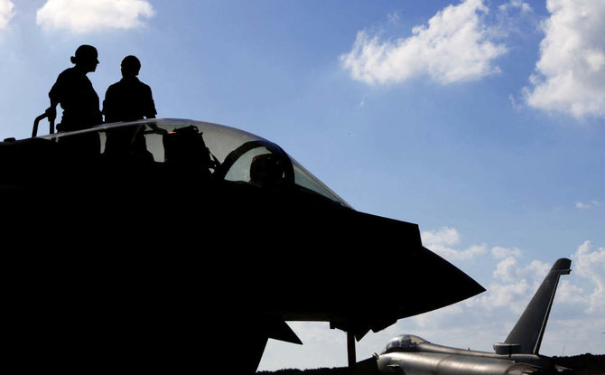 This photo taken on September 22, 2016 shows British soldiers standing on a Britain's Royal Air Force Eurofighter Typhoon fighter jet before taking off from RAF's Akrotiri base in Cyprus, for a coalition mission over Iraq. (AFP)