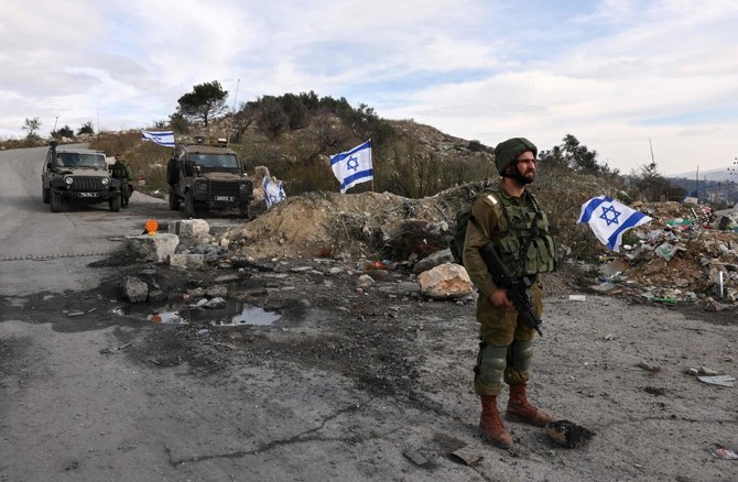 Above, Israeli soldiers guard a road at the former settlement of Homesh on Dec. 30, 2021. Israel’s settler movement has made Homesh a symbol of their cause. (AFP)