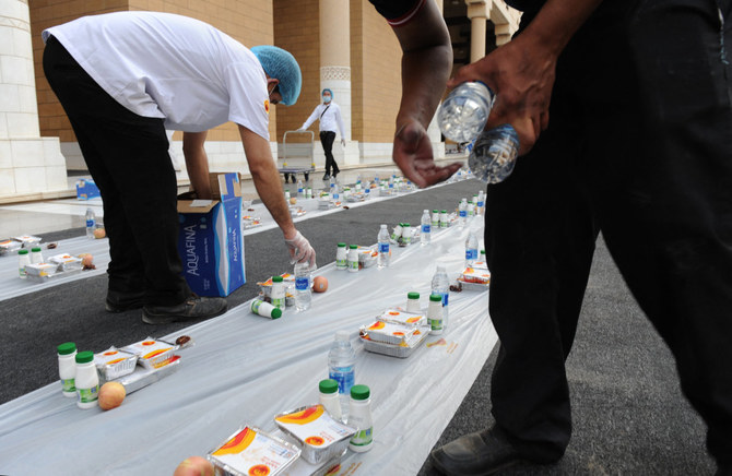 Volunteers arrange food and drink in preparation for the iftar meal at a mosque's courtyard in Riyadh. (AFP file)