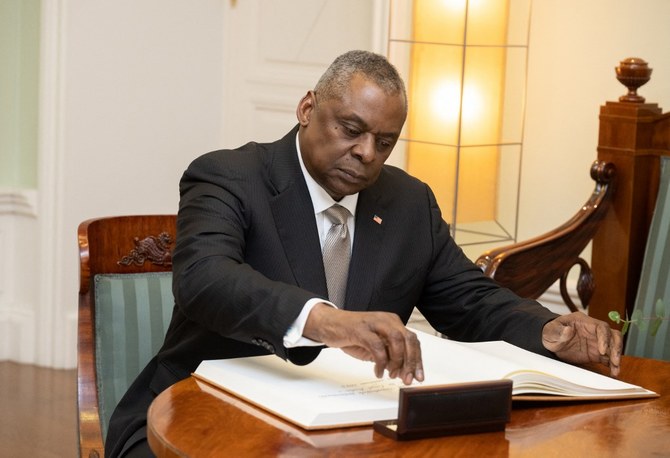 US Secretary of Defense Lloyd Austin signs the golden book prior talks with Estonia's Prime Minister (unseen) in Tallinn, Estonia, on February 16, 2023. (AFP)