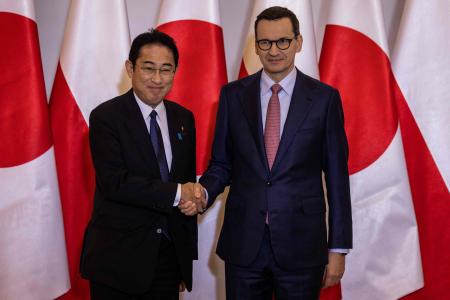 Japan's Prime Minister Fumio Kishida (left) and his Polish counterpart Mateusz Morawiecki shake hands prior to a meeting in Warsaw, March 22, 2023. (AFP)