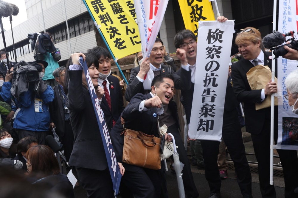 NITTA Shosei (C), director of the Japanese professional boxing association and supporter of Hakamada Iwao, raises his fist to show his joy at the court’s decision. (ANJ)