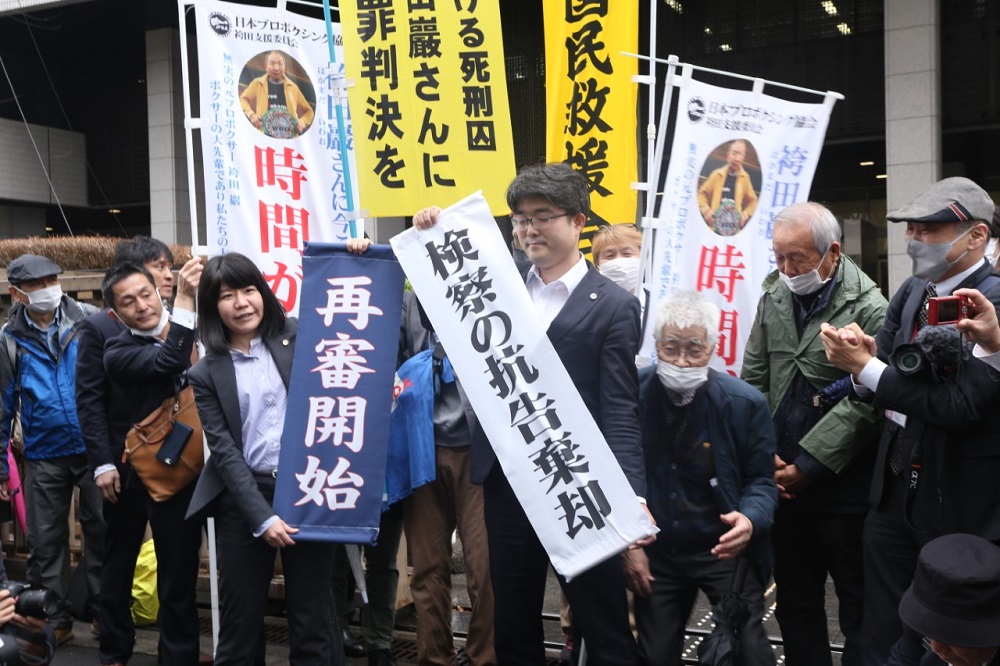 Lawyers of Hakamada Iwao show banners of the Tokyo High Court of Justice 