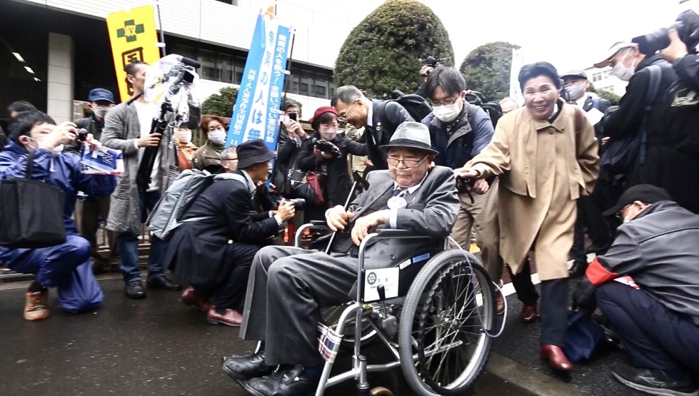 Hakamada, on a wheelchair, is escorted by his sister out of the Tokyo District Court building while members of the media crowded the place. (ANJ)