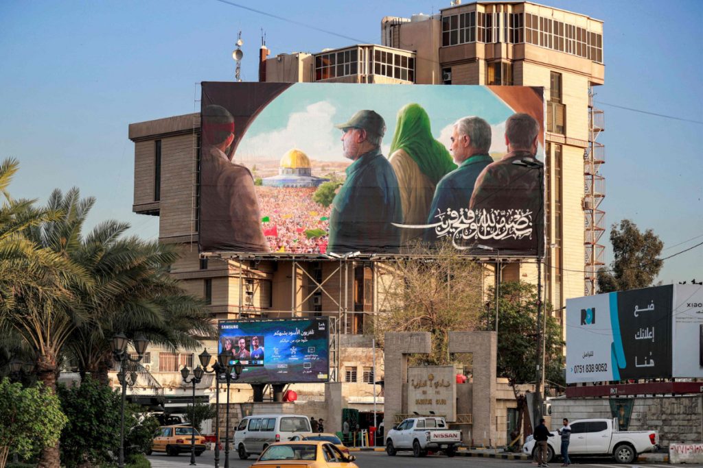 Vehicles drive past political graffiti murals along an underpass in Baghdad's Tahrir square on March 9, 2023. (AFP)