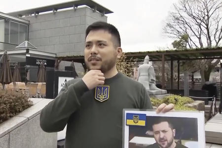 In this image made from video provided by Japan's NTV, a Japanese student speaks in an interview and says why he chose to be Ukrainian President Volodymyr Zelenskyy's look-alike for his graduation ceremony in Kyoto, western Japan, Friday, March 24, 2023. (NTV via AP)