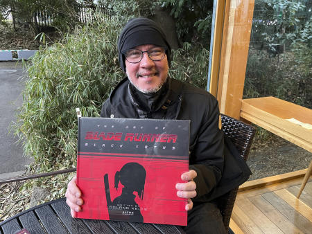 Japanese pop culture expert Roland Kelts holds a book about Blade Runner at Meiji Jingu in Tokyo on Feb. 25, 2023. (AP)