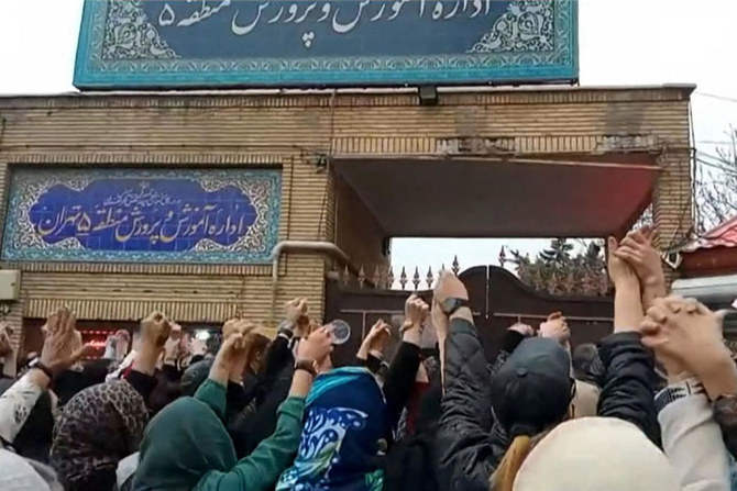 This grab taken from a UGC video made available on the ESN platform on March 4, 2023, shows families gathering and chanting slogans outside an education ministry building in Tehran, following poisoning attacks on students. (RADIO FARDA/ AFP)
