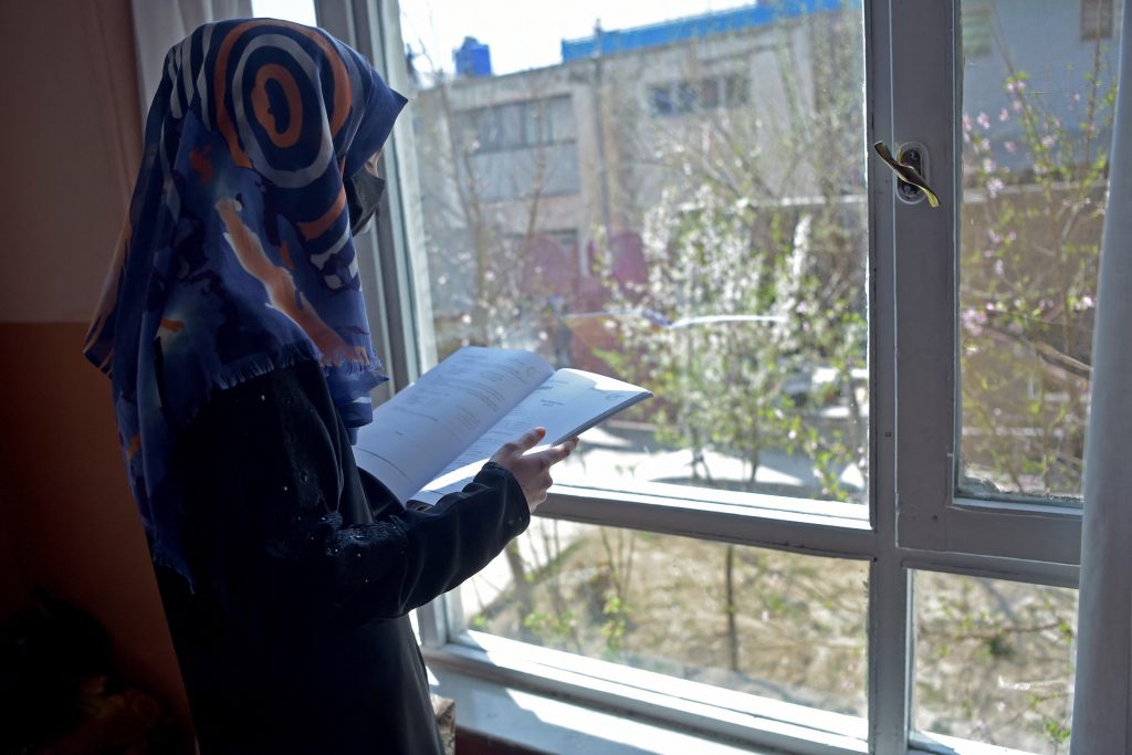 A woman reads a book at her residence in Kabul, March. 21, 2023. (AFP)