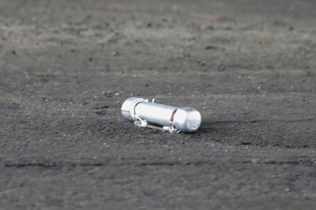 A suspicious object is seen on the ground where a suspect was arrested before Japanese Prime Minister Fumio Kishida was to begin his speech, at the Saikazaki port in Wakayama prefecture, western Japan, on Saturday. (Kyodo News via AP)