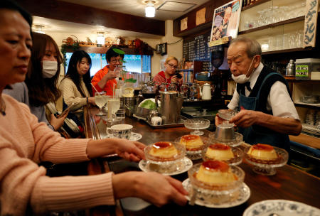 Shizuo Mori serves a pudding to customers at his Heckeln coffee shop in Tokyo, March 15, 2023. (Reuters)