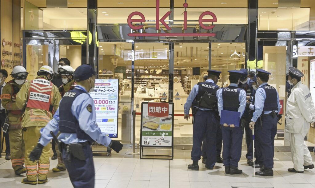 Police officers gather at the entrance of the commercial complex