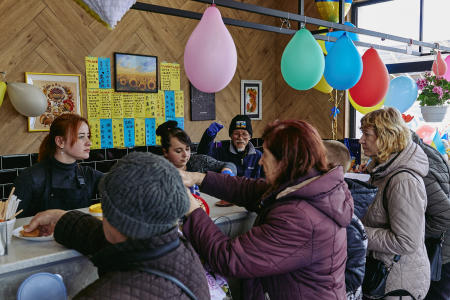 Fuminori Tsuchiko passes free food to people at his café in Kharkiv, Ukraine April 24, 2023. (Reuters)