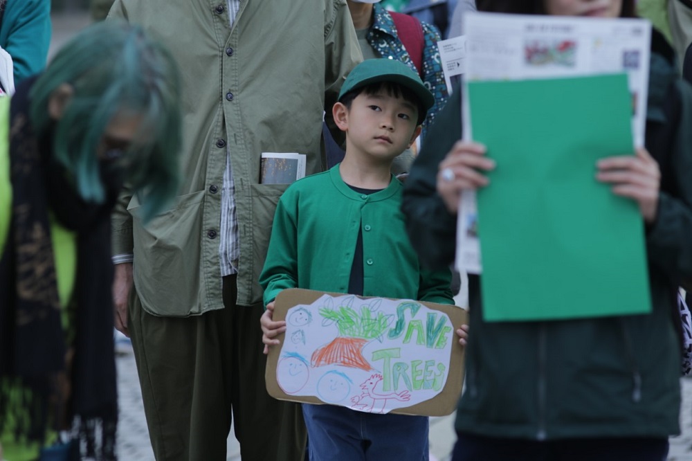 Around 100 environmental activists gathered on Sunday to protest against the planned destruction of more than 3,000 century-old trees in order to build sports facilities and commercial properties in central Tokyo. (ANJ/ Pierre Boutier)